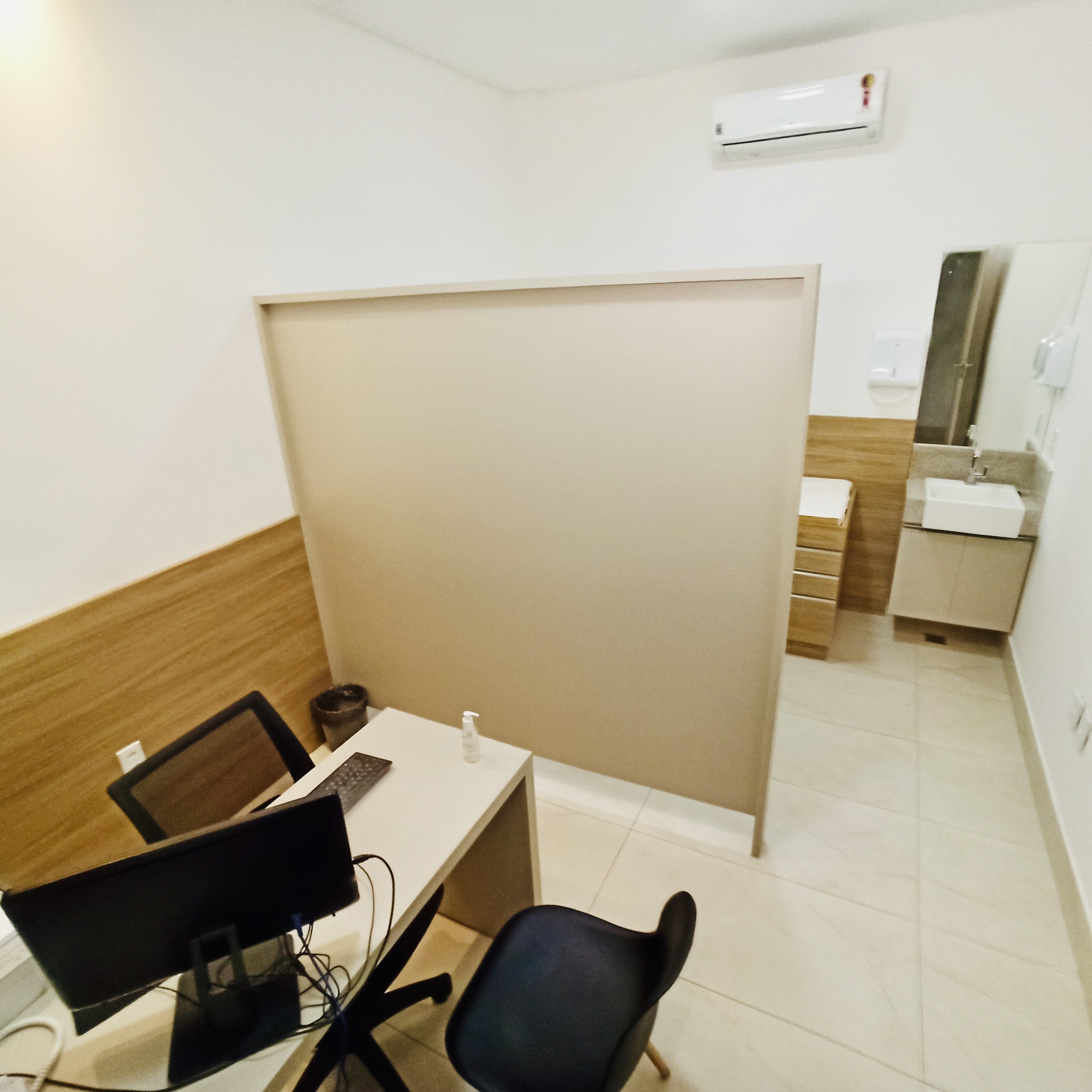 Consultório clínico do Instituto Valler com mesa de atendimento e banheiro.